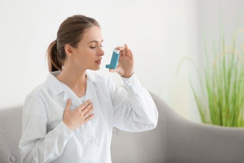 femme qui respire dans une ventoline en raison de l'asthme