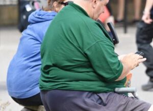 homme adulte obèse assis vu de dos