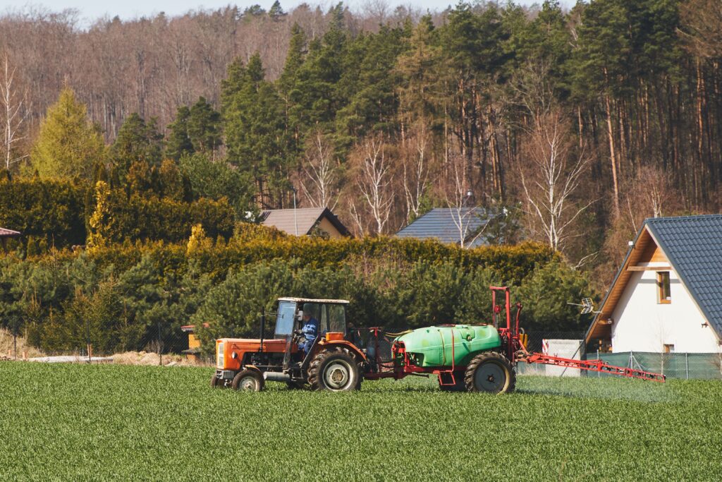 Un tracteur épand des pesticides à proximité d'habitation.