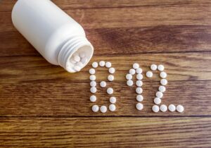 Gélules de vitamine B12 qui sortent d'un flacon en plastique et dessinent les lettres B et le nombre 12.